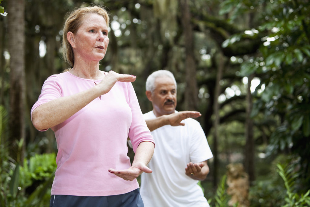 a group of seniors doing tai chi in the park