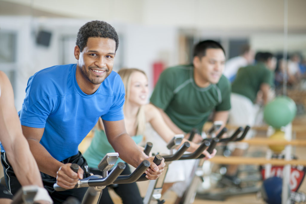 A group of adults doing aerobic exercise in a bicycle spinning class.