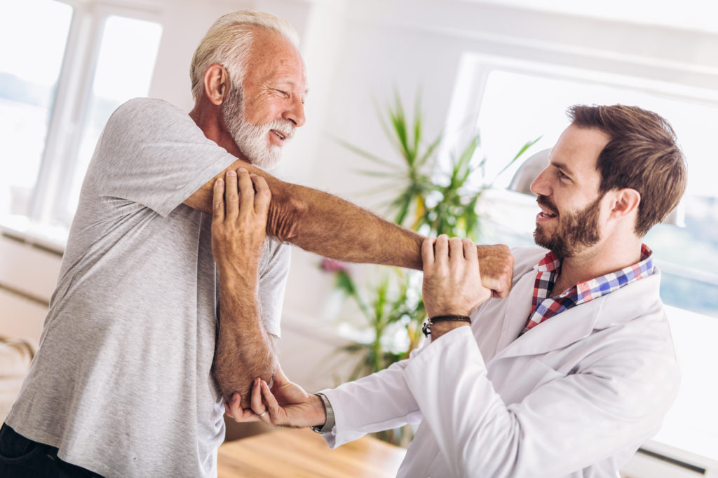 Elder man being treated by physical therapist