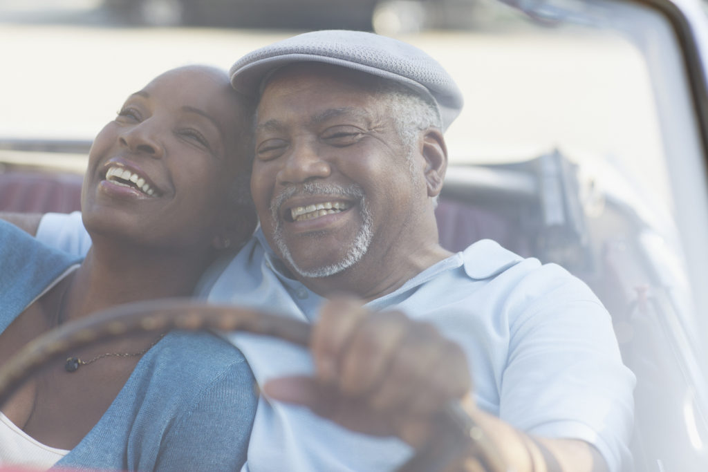 Older African American couple driving in convertible together