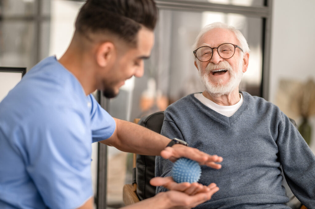 Older man undergoing a session of physical therapy conducted by an experienced rehabilitation doctor