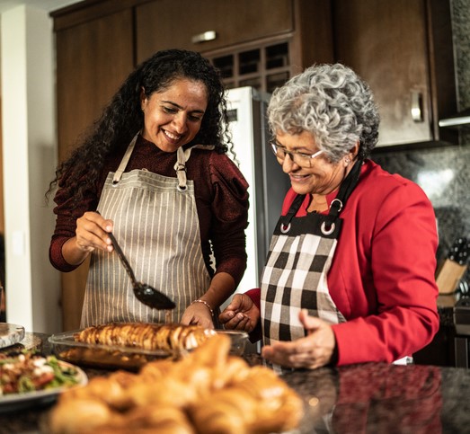 A woman and her senior mother cook a holiday meal together